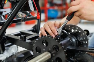 Worker make a ATV in the workshop. Preparing the quad bike for sale.